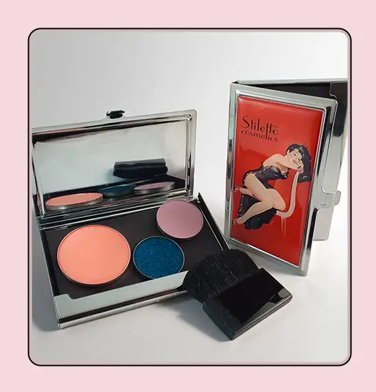 Open custom makeup compact printed with pin-up artwork, held in hand